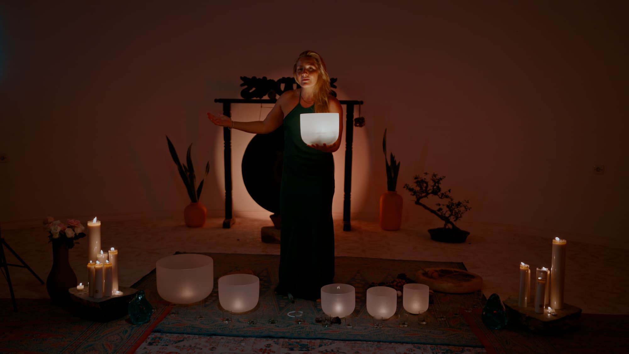 Camila Rivera playing crystal singing bowls during a sound healing ceremony