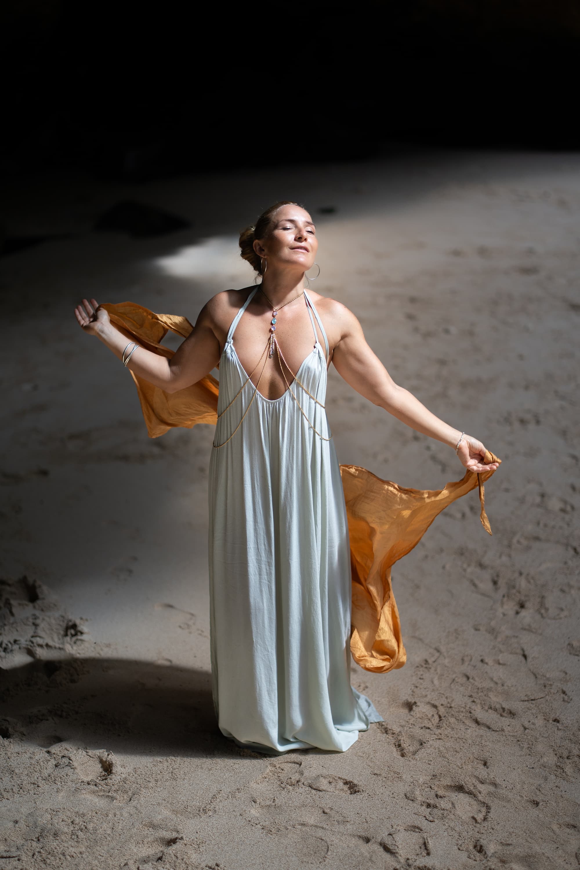 Camila Rivera holding a gold incense vessel on the beach in Bali